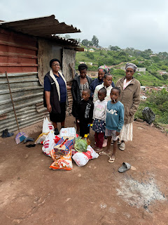 Gogo Ngcayi's family outside the metal home where nine people were living in November 2024