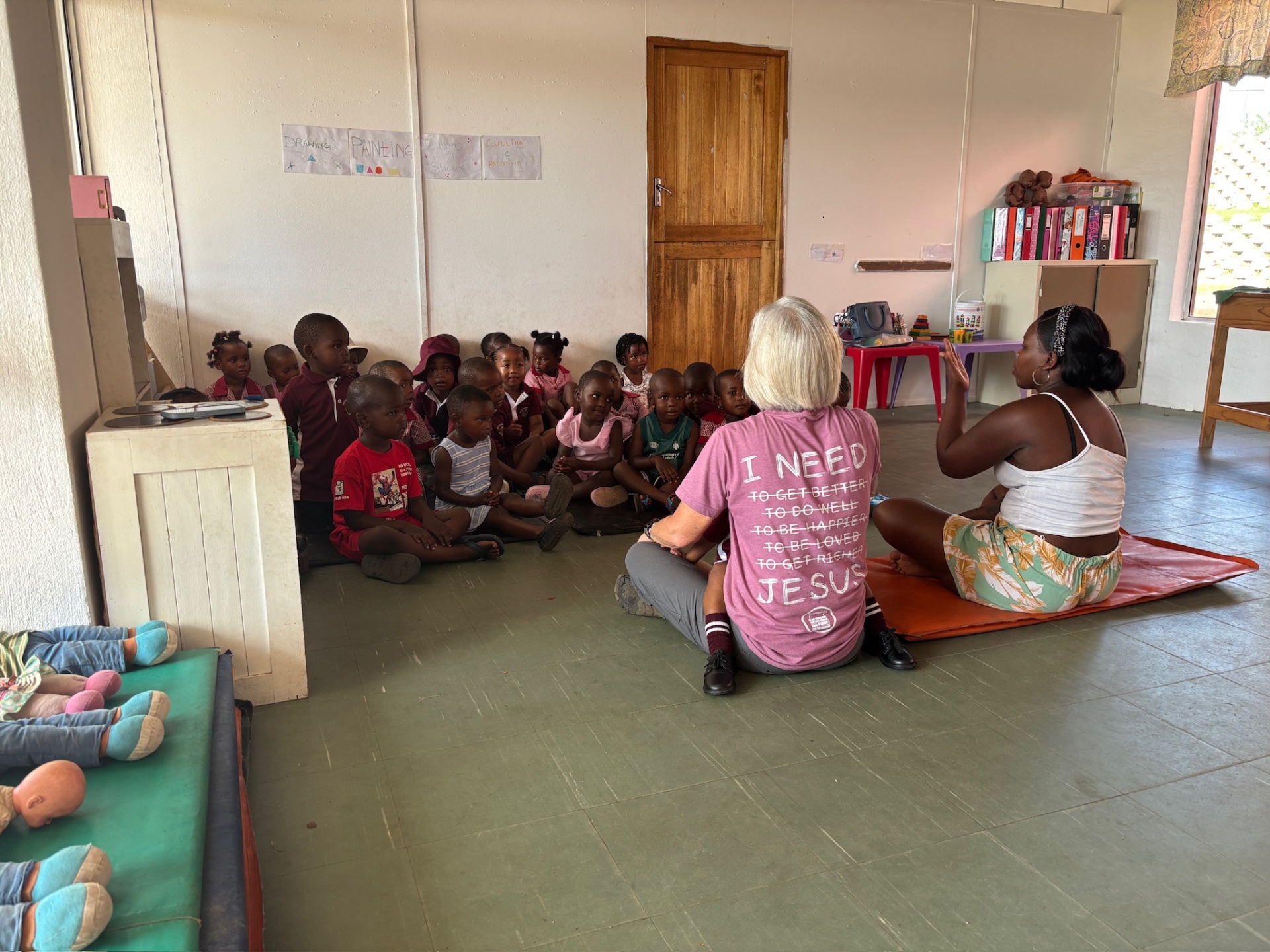 A visitor teaching a classroom of uniformed crèche children