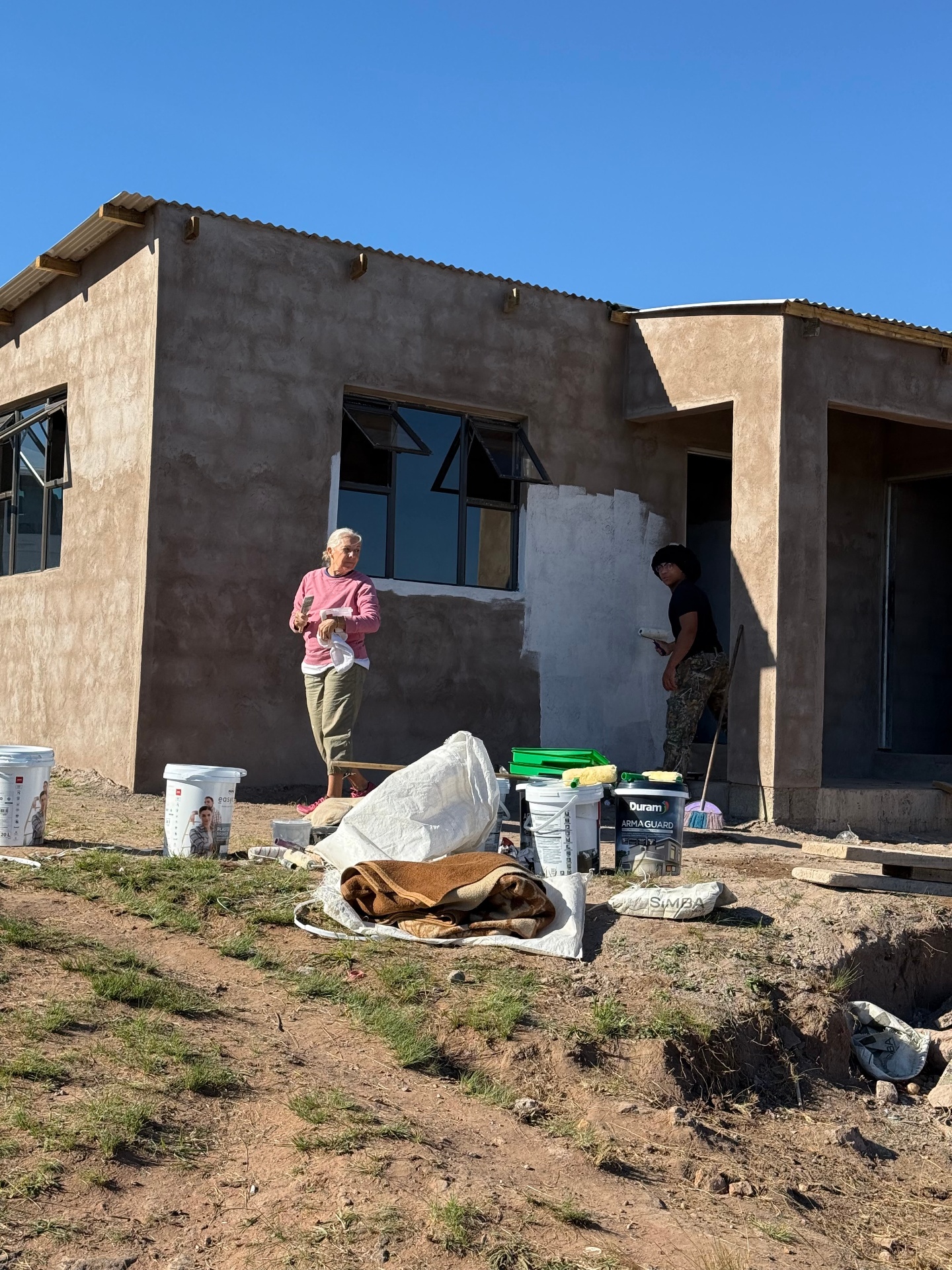 Painting the exterior of Gogo Ngcayi's new home in June 2025