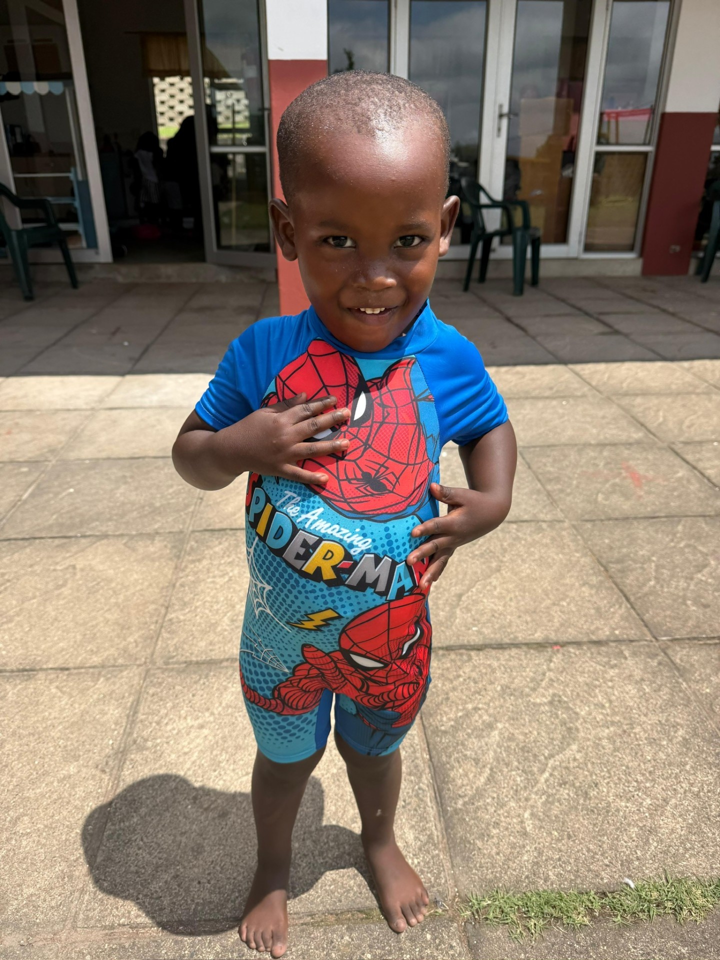 A small boy smiling on the crèche patio