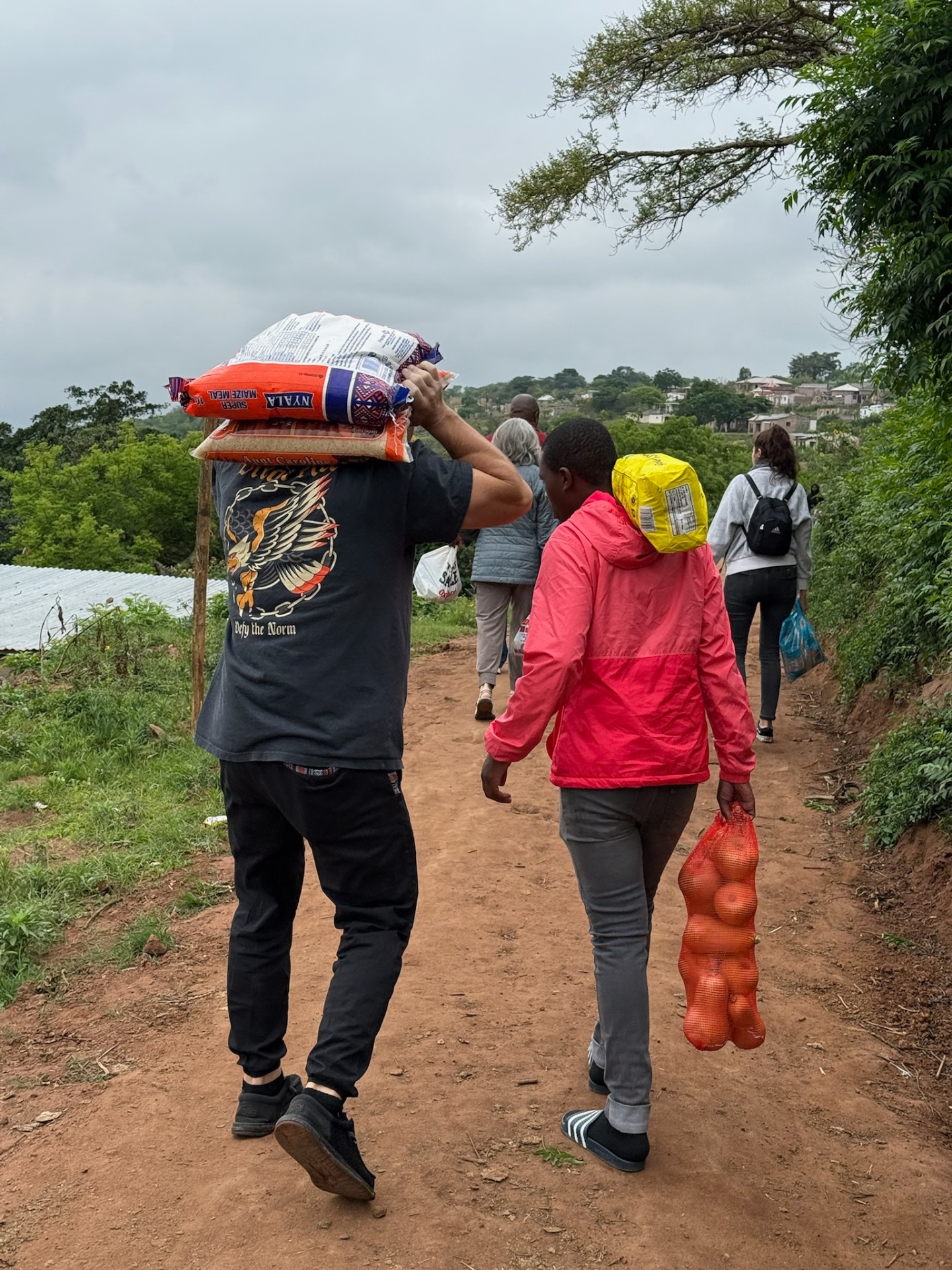 Carrying food parcels along a Ntshongweni footpath