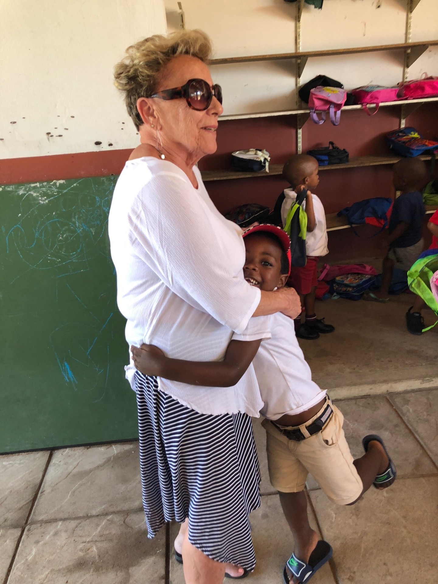 A mission friend receiving a full-body hug from a little boy
