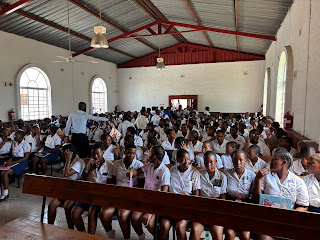 A packed Ntshongweni church on a Sunday morning, filled with children and families in uniform