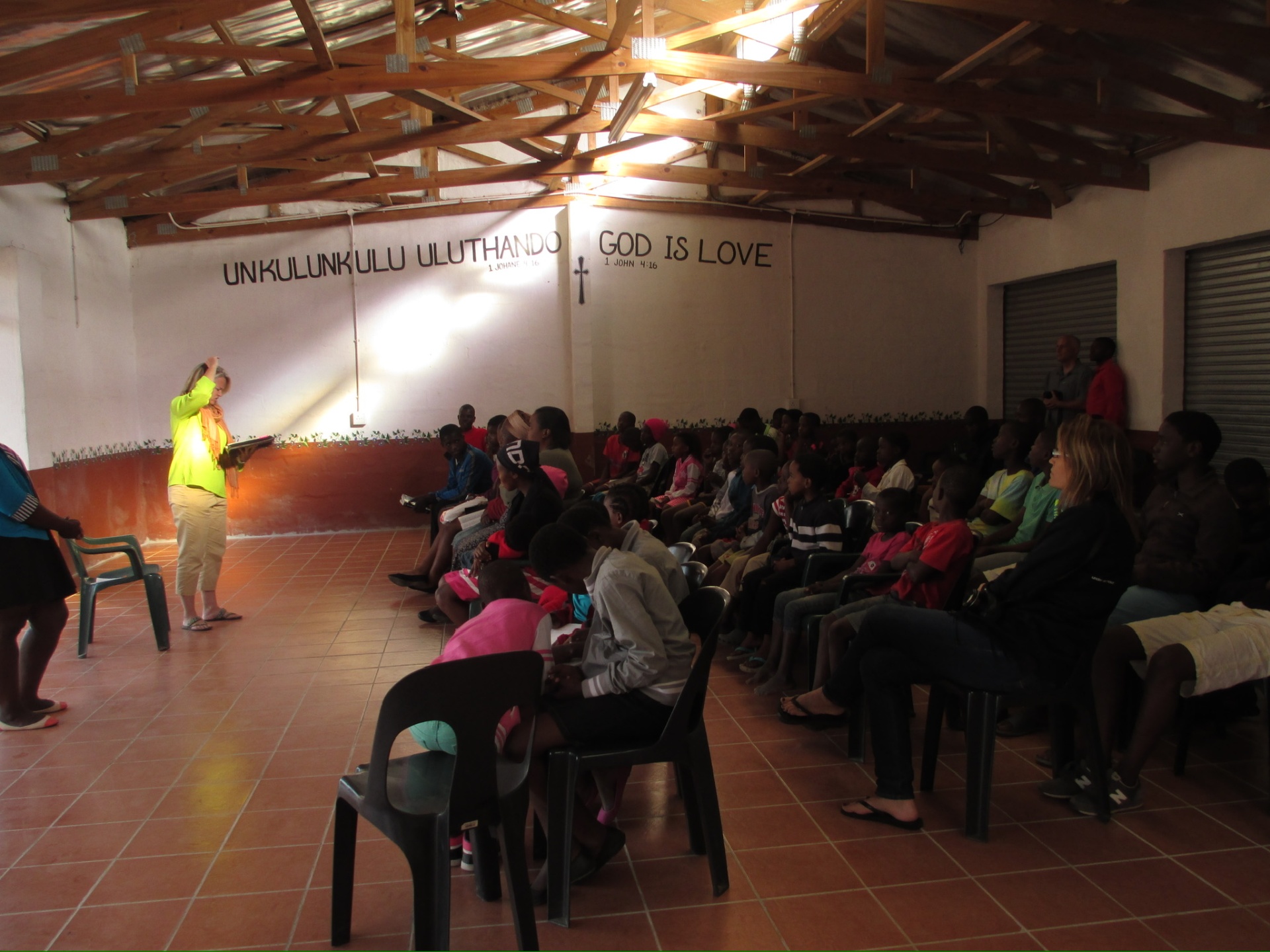 A teacher leading a youth lesson in a community hall