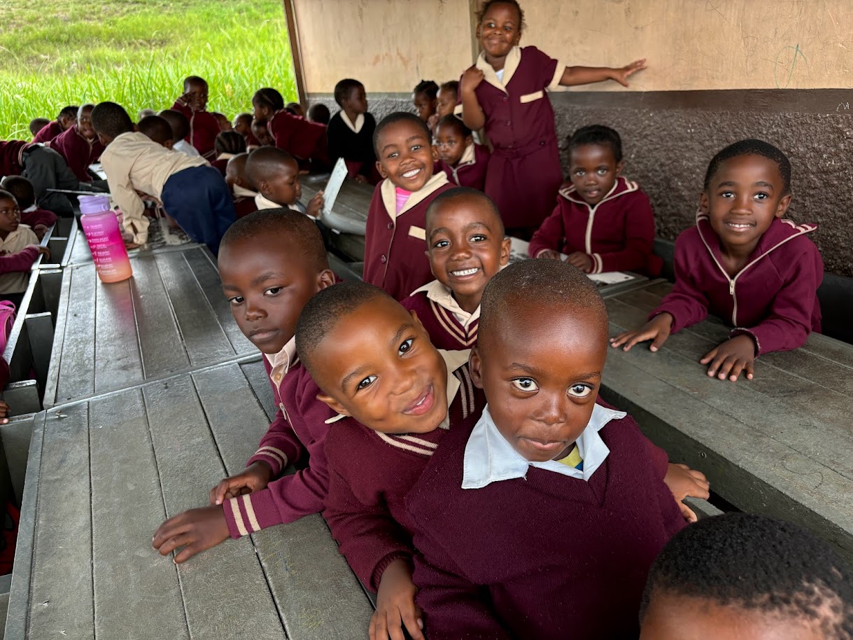 Smiling schoolboys leaning on wooden desks