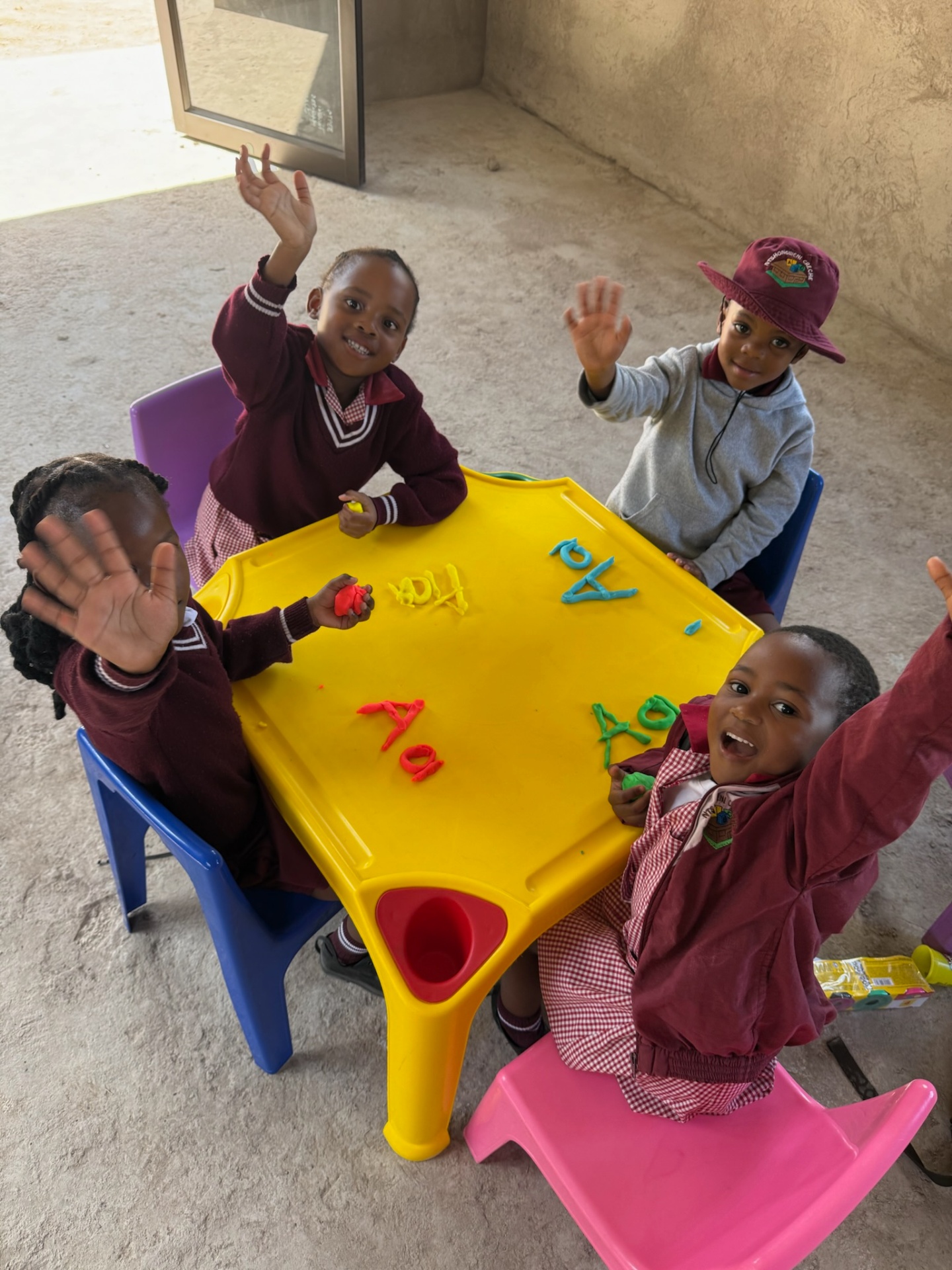 Ntshongweni Crèche children waving around a craft table