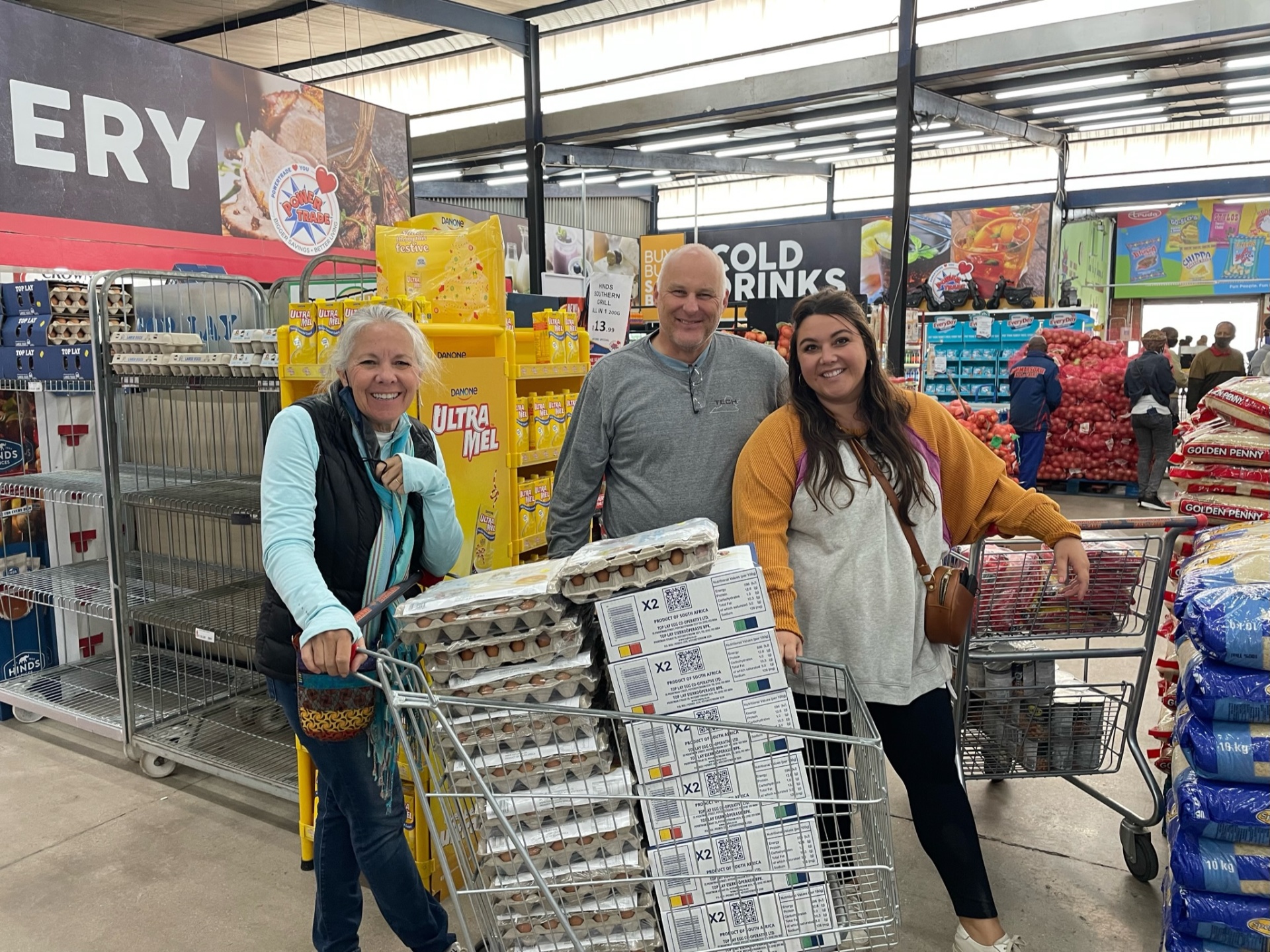 The team filling shopping carts with eggs, maize meal, and staples at the wholesaler before a food-parcel run