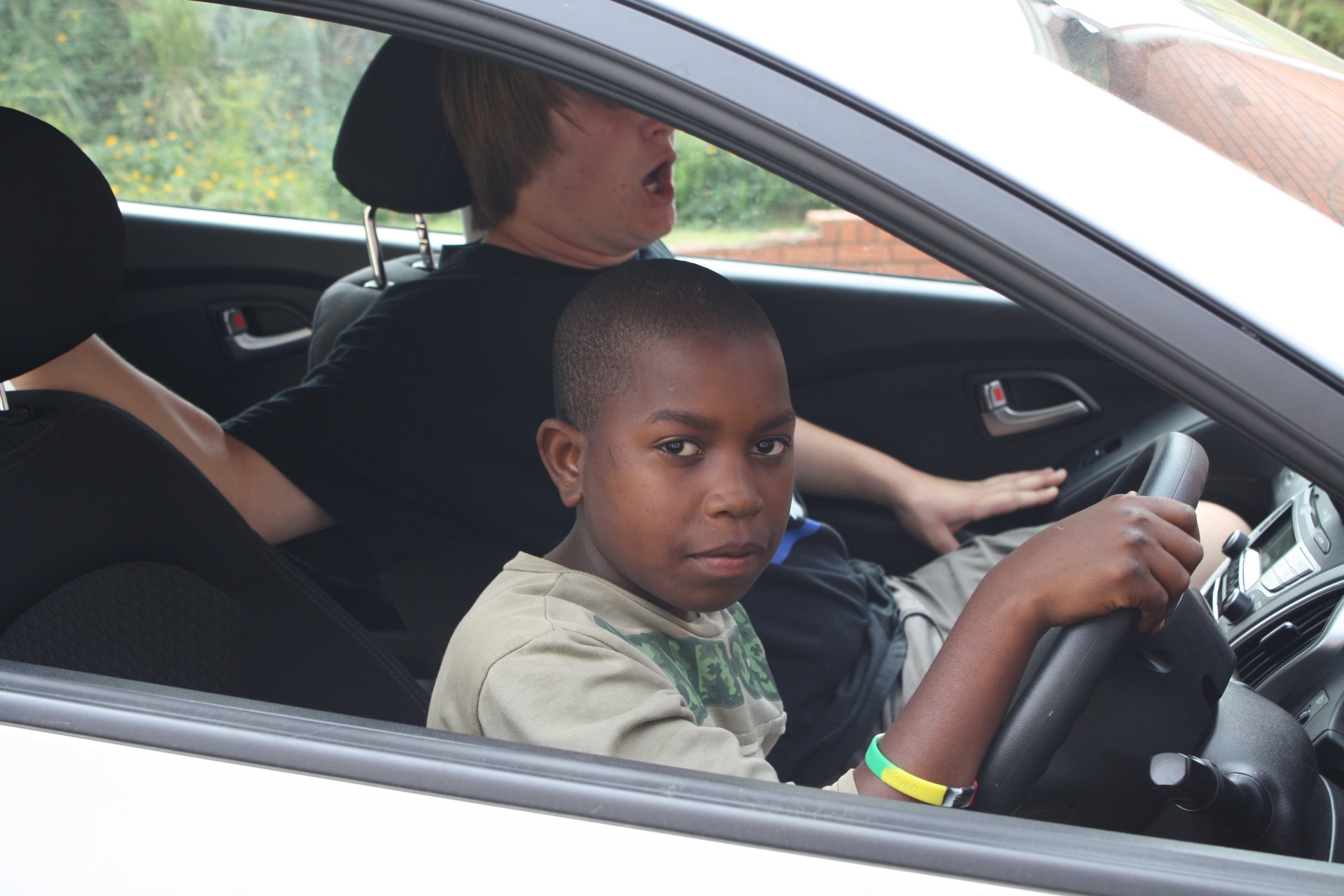 Joe as a boy at the wheel of a rental car on a country road