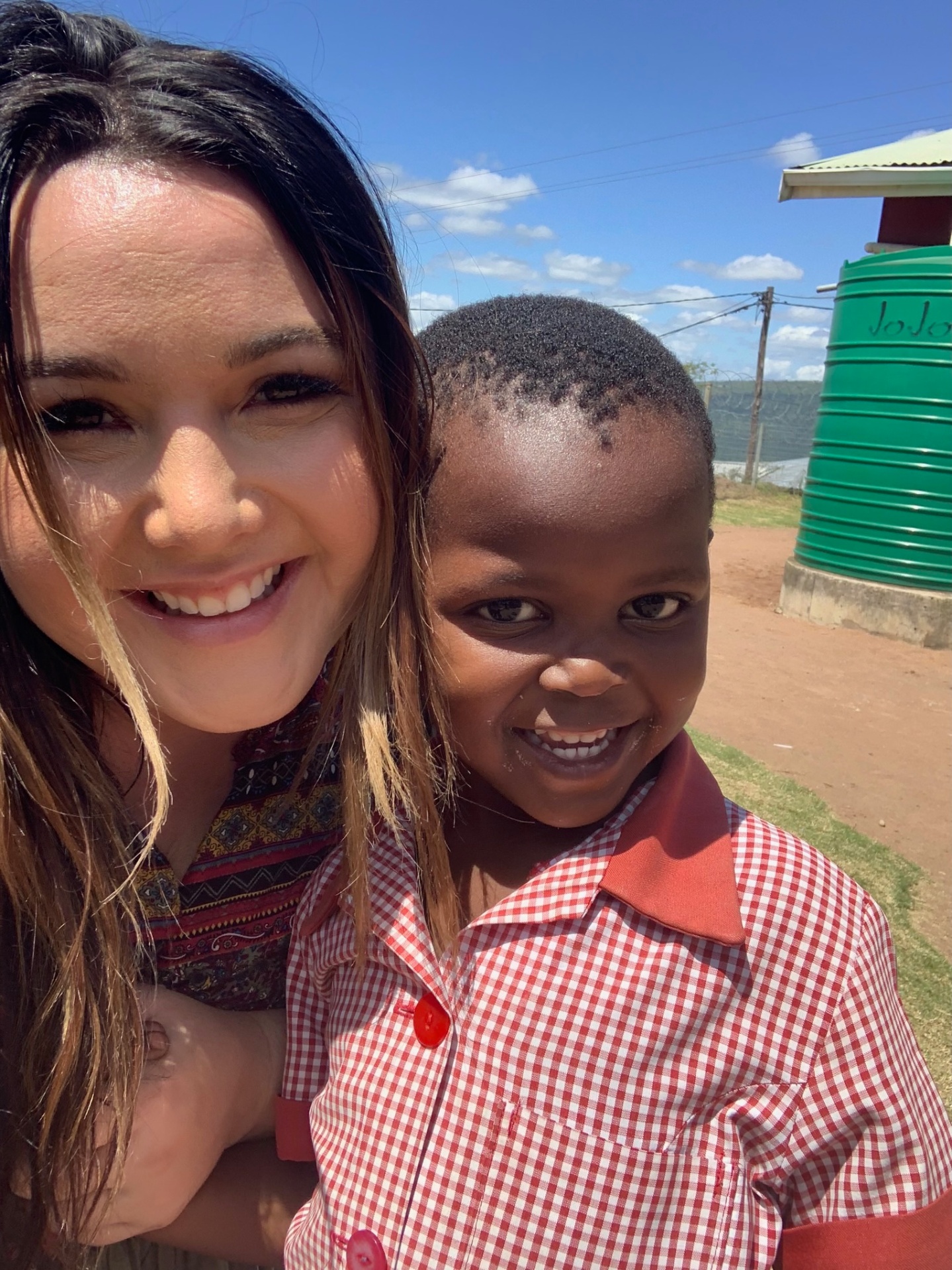 A joyful selfie of a friend with a schoolboy by a JoJo tank