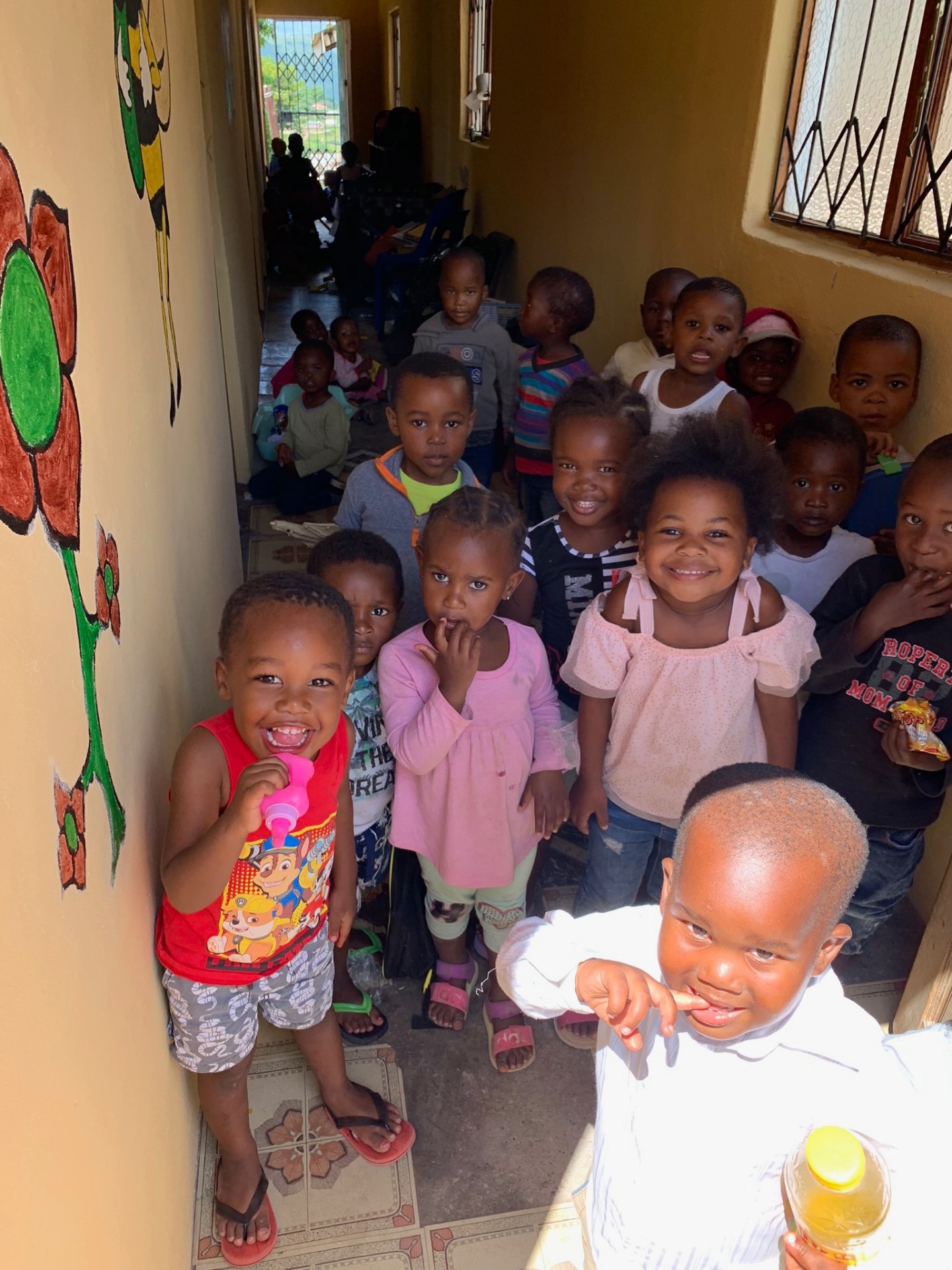 Laughing toddlers in a crèche hallway