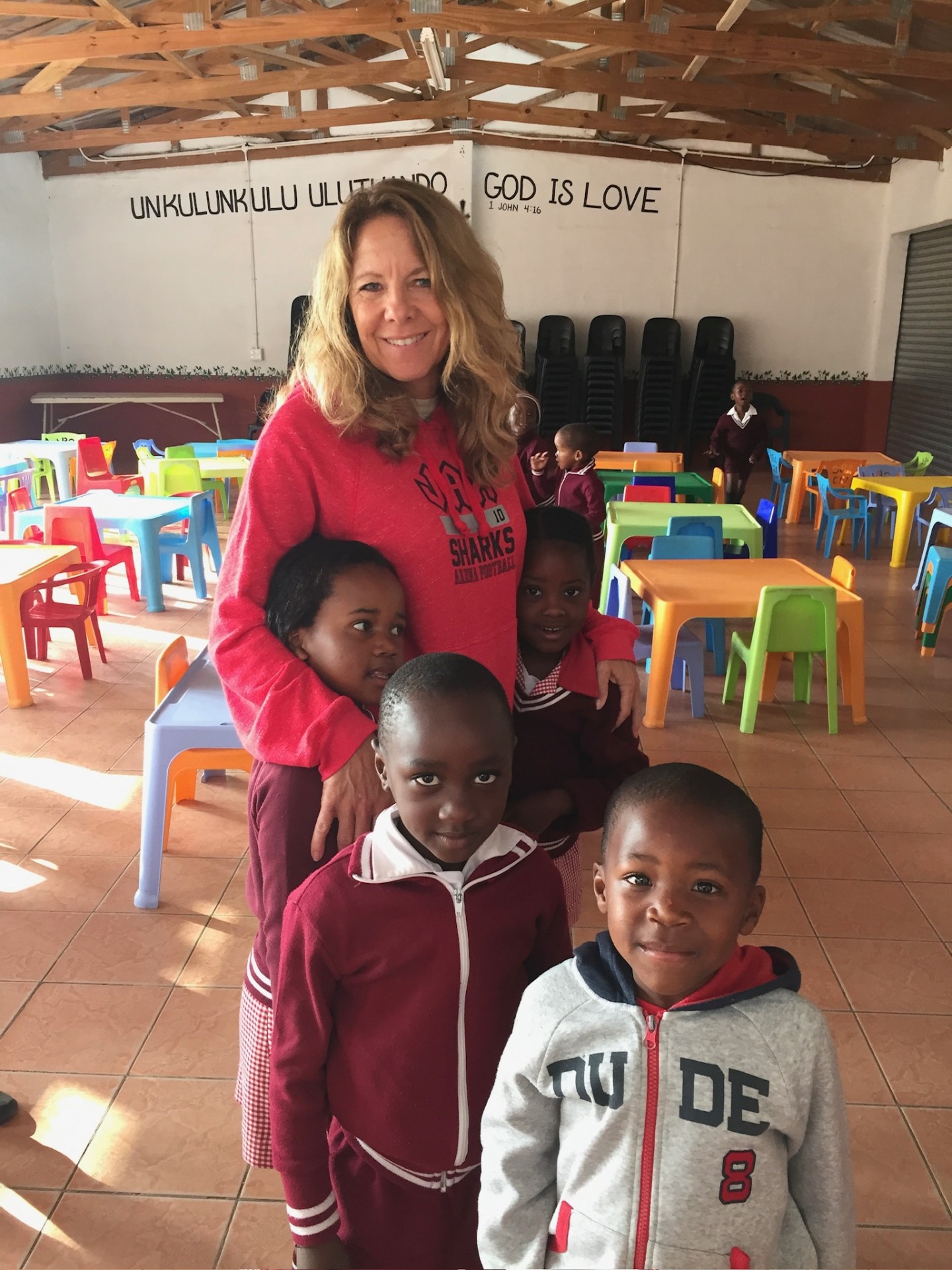 A friend of the mission with children in a bright crèche classroom
