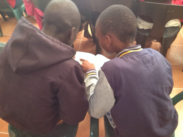 Two boys reading together in a classroom