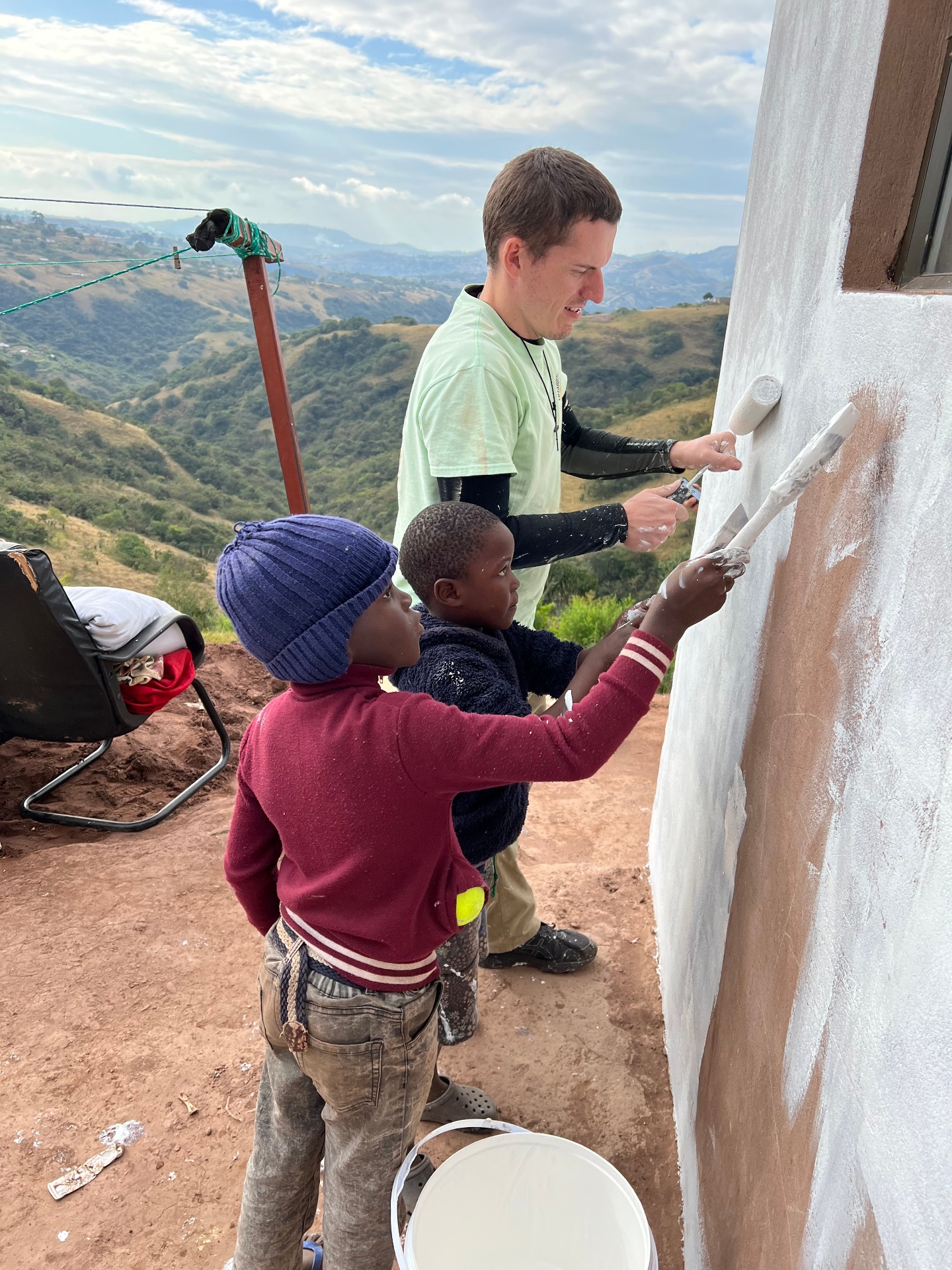 Painting the walls of Ntombikayise's home with her children